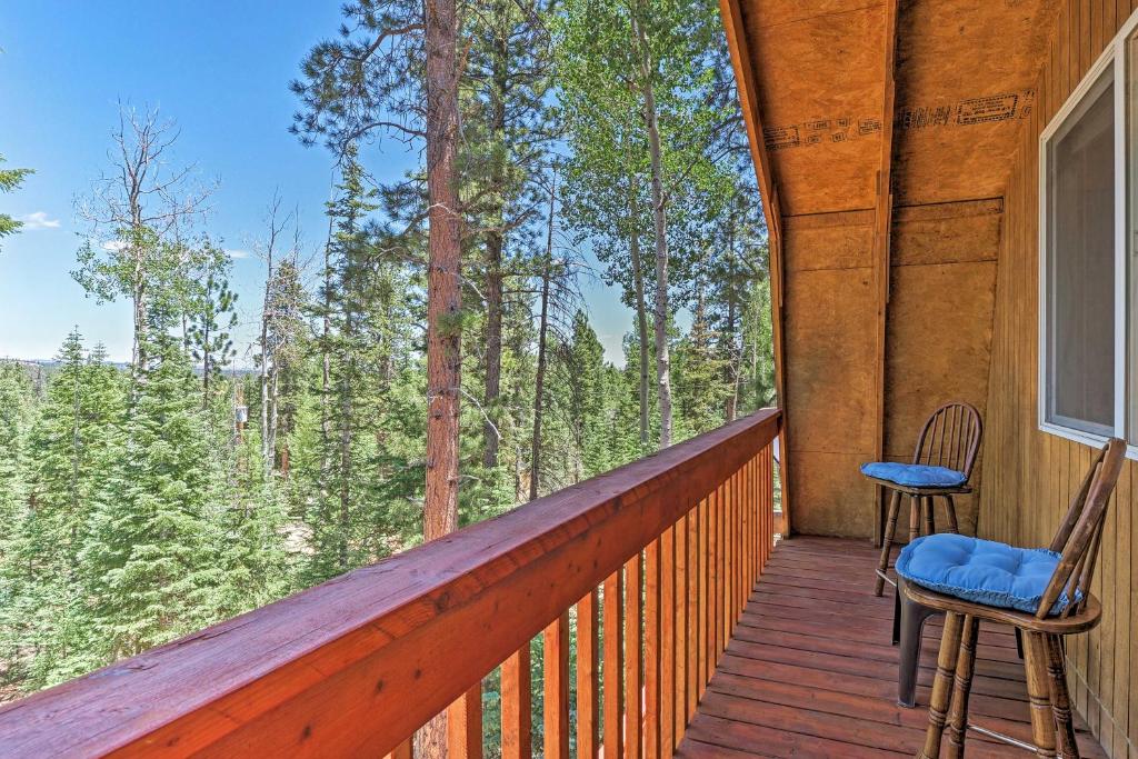 a porch with two chairs and a view of the forest at Scenic Duck Creek Escape 30 Mi to Brian Head in Duck Creek Village
