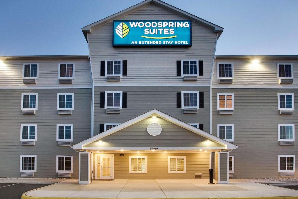 a building with a sign on the front of it at WoodSpring Suites Manassas Battlefield Park I-66 in Manassas