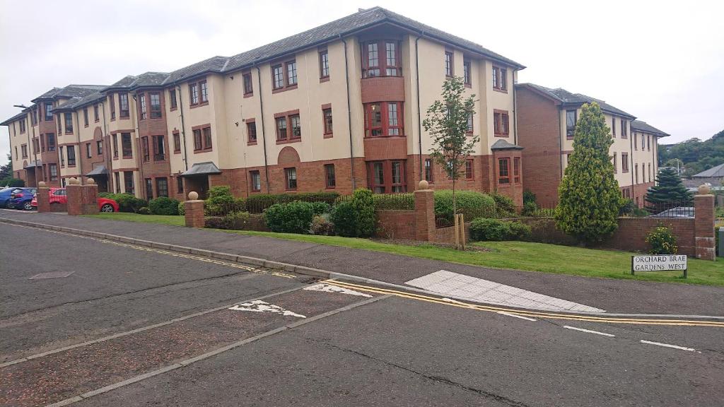 an empty street in front of a large building at Orchard Apartment in Edinburgh