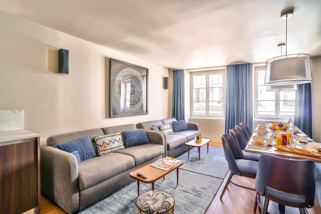 een woonkamer met een bank en een tafel bij 130 - Urban Brand New 110m2 Flat in Montorgueil in Parijs