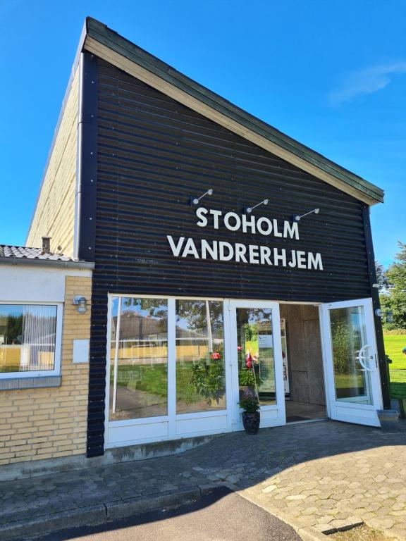 Stoholm的住宿－Stoholm Vandrehjem，前方有读车站标牌的商店