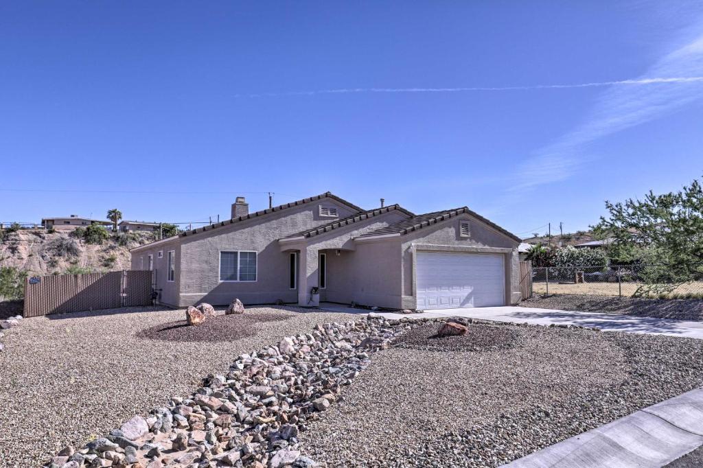 a house with a pile of rocks in front of a driveway at Inviting Retreat with Patio Less Than 1 Mi to Colorado River in Bullhead City