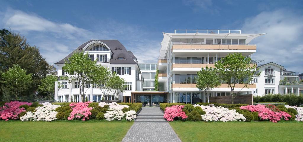 ein großes weißes Gebäude mit Blumen davor in der Unterkunft RIVA - Das Hotel am Bodensee in Konstanz
