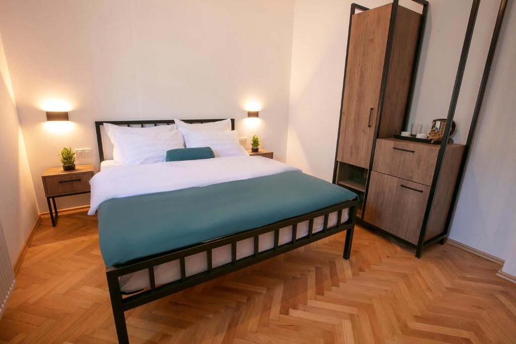 1 dormitorio con 1 cama grande y suelo de madera en Grand Boutique Hotel, en Pristina