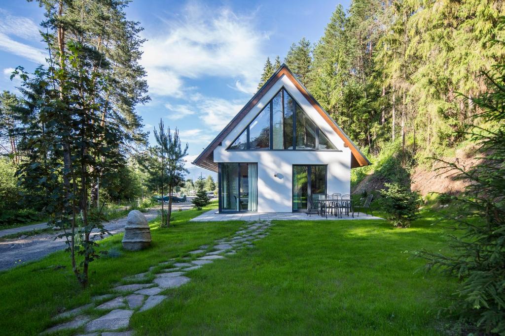 a house on a hill with a green yard at VESPERA SK - Chaty Jasna - Silent place - Unique design in Liptovský Mikuláš