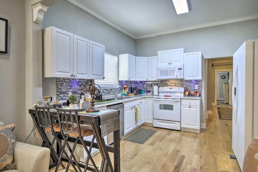 a kitchen with white cabinets and a table and chairs at Updated Ybor City House with Fenced Yard in Tampa