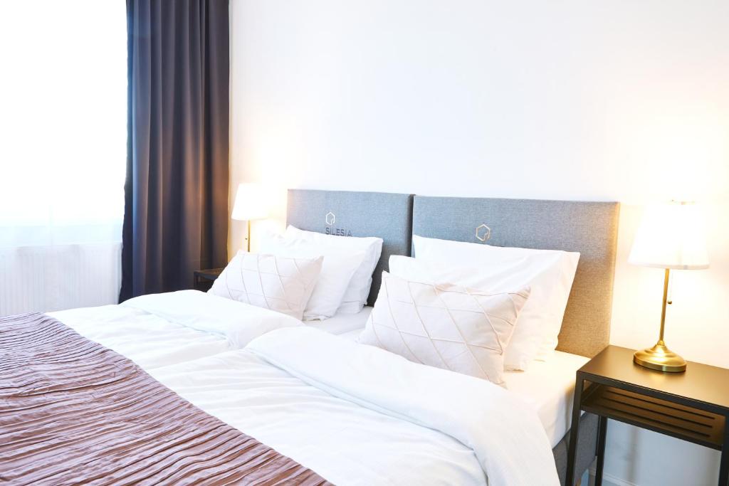Posteľ alebo postele v izbe v ubytovaní Silesia Apartments