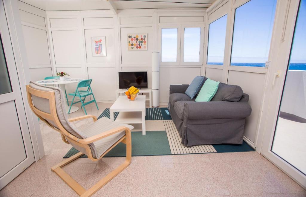 a living room with a couch and a chair at Arinaga Colors, tu casa en la playa in Arinaga