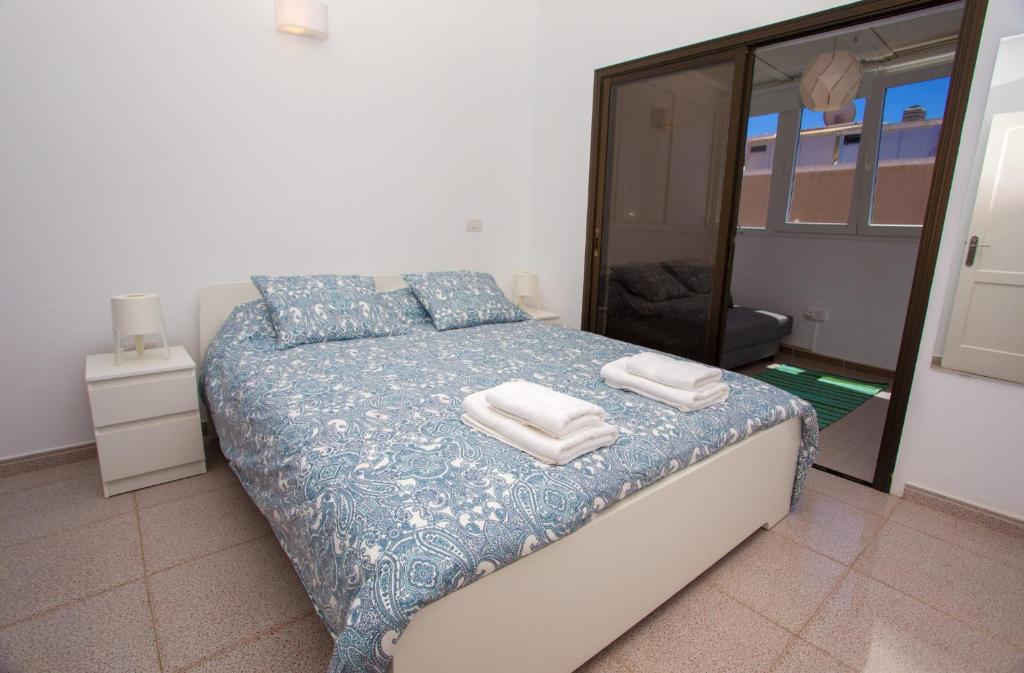 a bedroom with a bed with towels on it at Arinaga Colors, tu casa en la playa in Arinaga