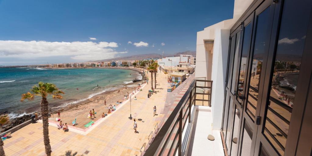 a view of the beach from a balcony of a building at Arinaga Colors, tu casa en la playa in Arinaga