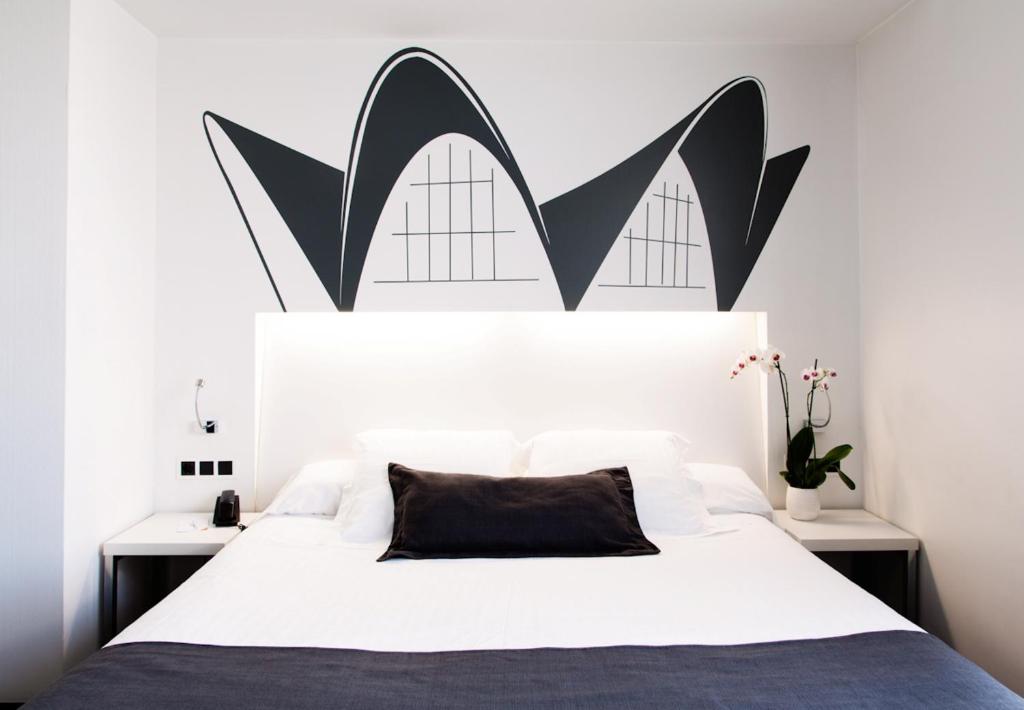 a bedroom with a bed with a black and white headboard at Hotel Dimar in Valencia