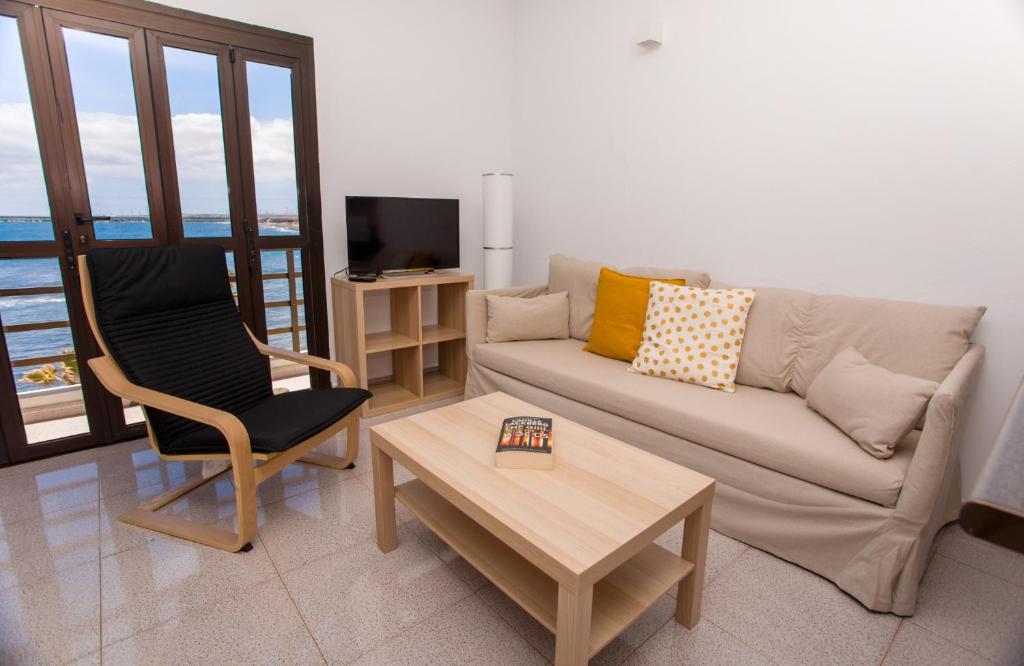 a living room with a couch and a table at Arinaga Colors, tu casa en la playa in Arinaga