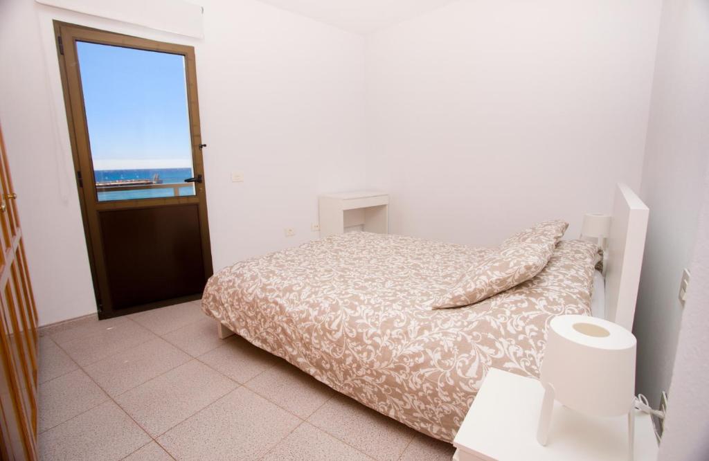 a bedroom with a bed with a view of the ocean at Arinaga Colors, tu casa en la playa in Arinaga