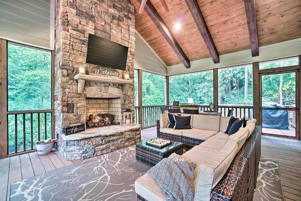 a living room with a couch and a stone fireplace at Hootenanny at Horton Creek Creekside Escape! in Helen