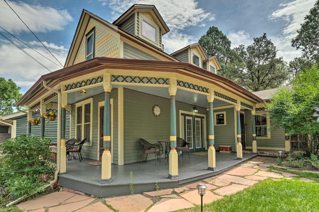 uma casa verde com um alpendre com um pátio em Historic Manitou Springs Victorian Walk Downtown! em Manitou Springs