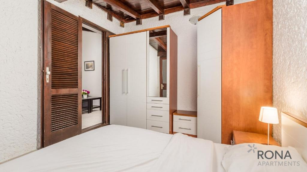 sypialnia z białym łóżkiem i lustrem w obiekcie Rona Holiday Home Ana w Poreču