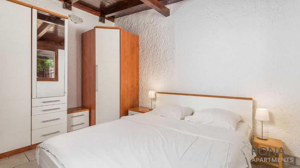 sypialnia z białym łóżkiem i oknem w obiekcie Rona Holiday Home Ana w Poreču