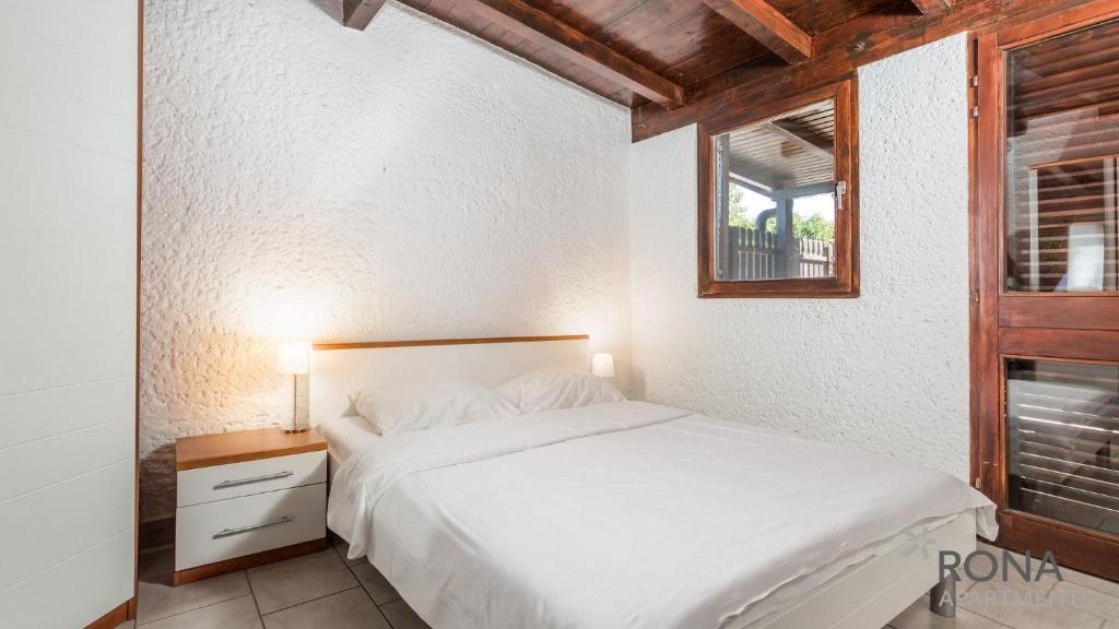 sypialnia z białym łóżkiem i oknem w obiekcie Rona Holiday Home Ana w Poreču