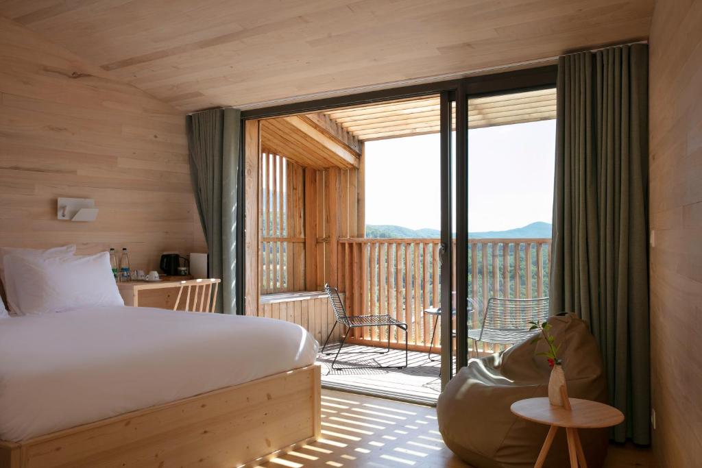 - une chambre avec un lit et un balcon dans l'établissement Hôtel 48°Nord & Restaurant, The Originals Relais, à Breitenbach