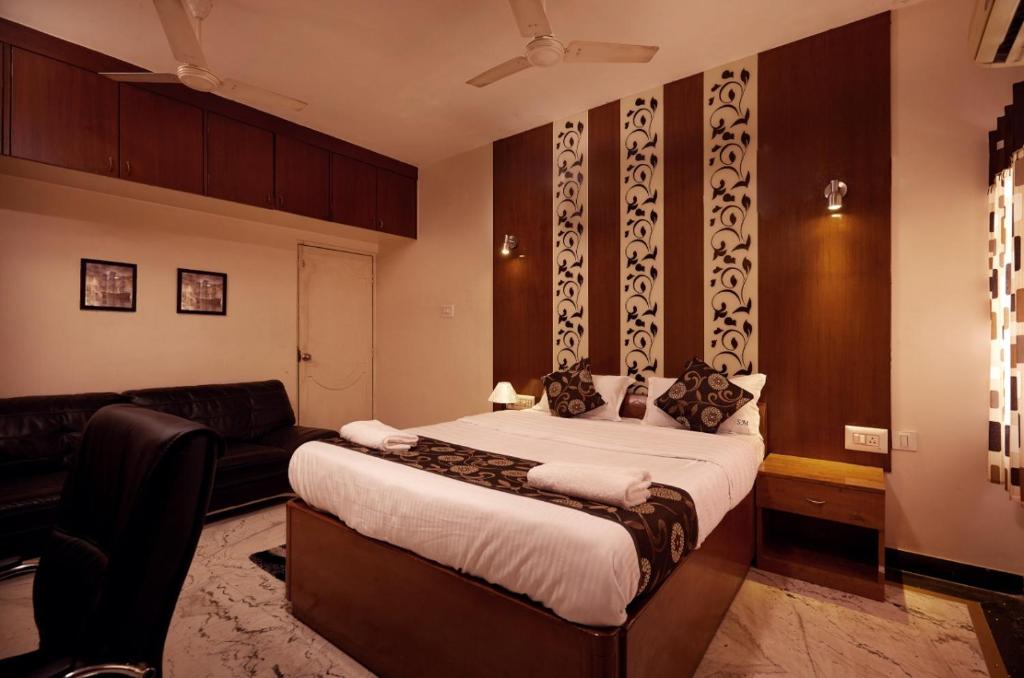 a bedroom with a large bed and a couch at Sweet Memories- Perfect home stay in Chennai