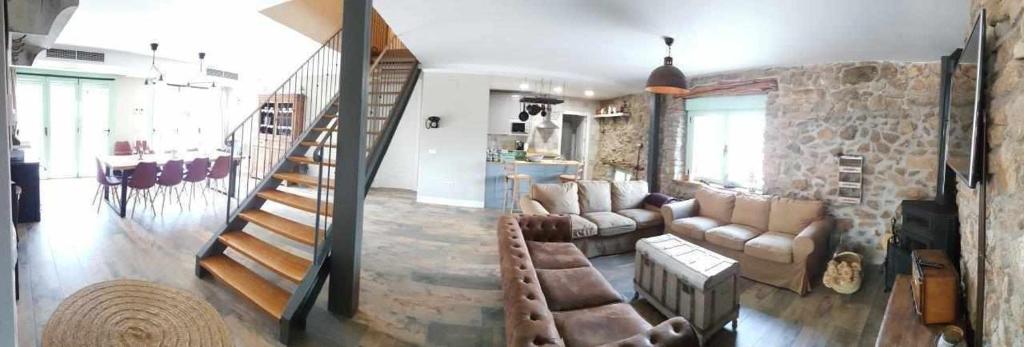 a living room with a couch and a staircase at Casa Rural Rojo del Tietar in La Iglesuela