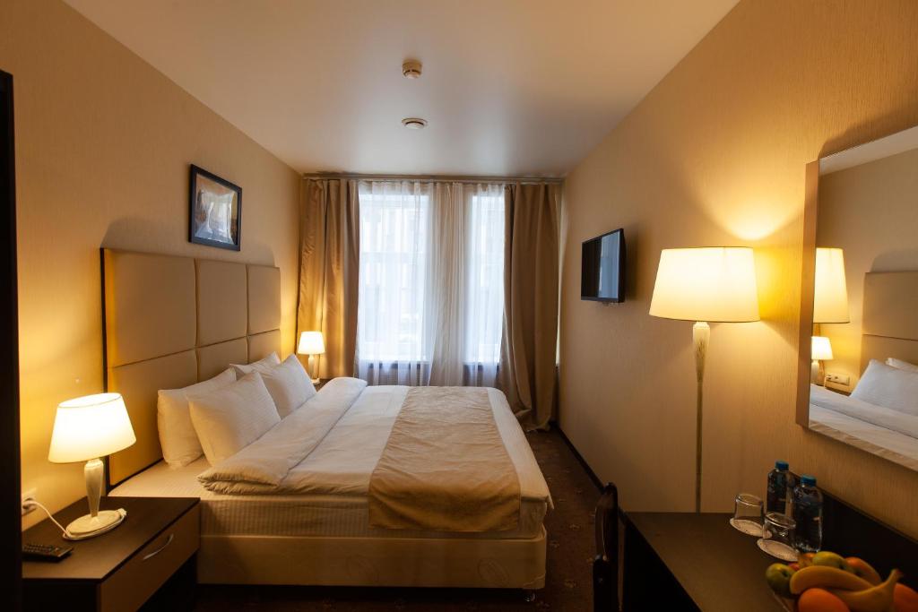 
a hotel room with two beds and a television at Boris Godunov Hotel in Moscow
