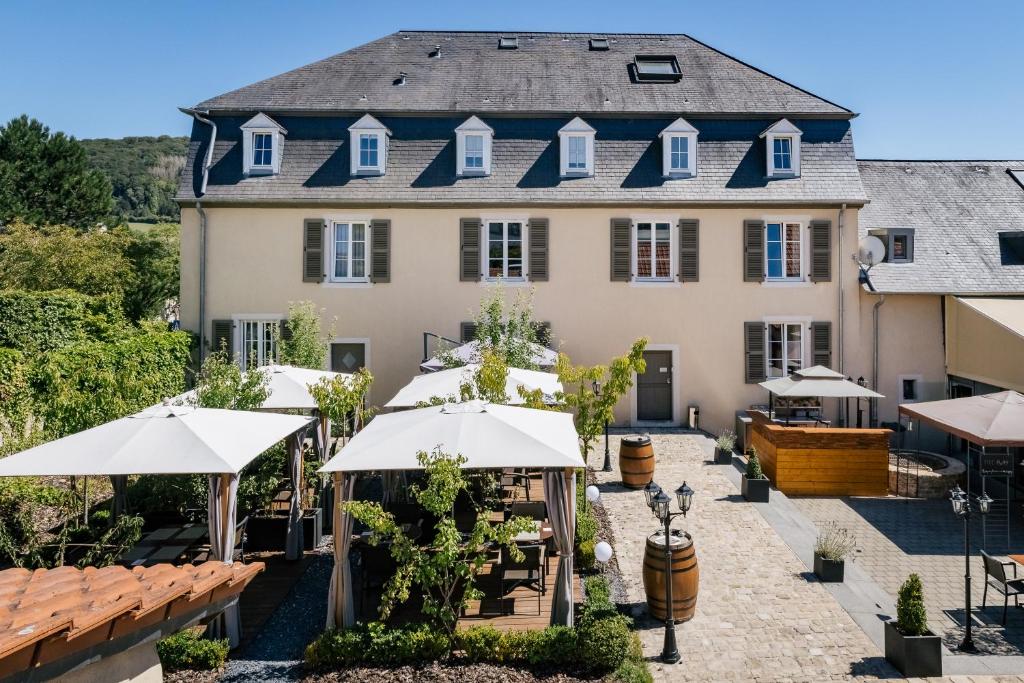 a building with umbrellas in front of it at Restauberge Peitry in Roodt-sur-Syre