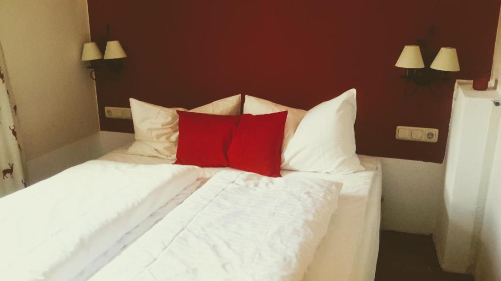 a bed with two red pillows on it at Superior Apartment Recktenwald in Bad Gastein