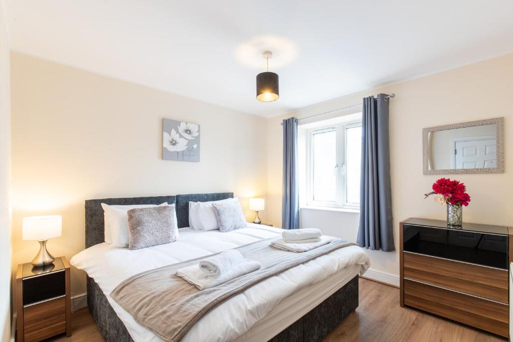 a bedroom with a large bed and a window at 1-bedroom apartment with balcony, Hoddesdon in Hoddesdon