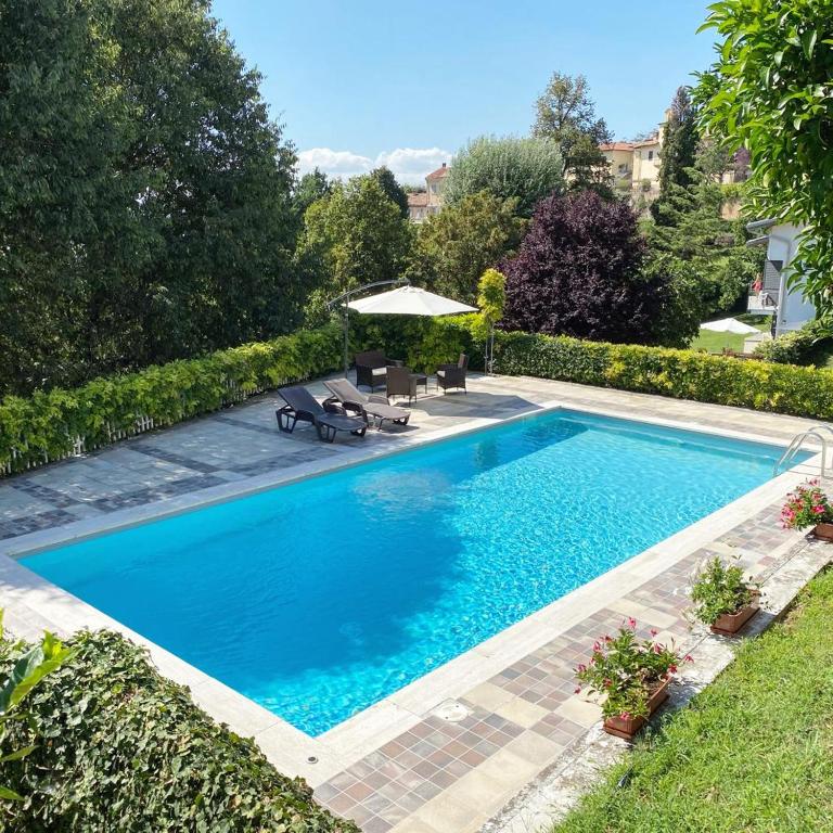 a swimming pool with blue water in a yard at Da Zoe in Moncalvo