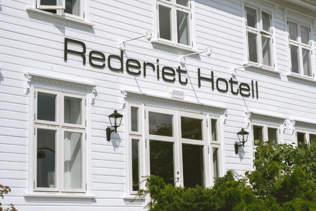 un edificio blanco con un cartel de hotel en Rederiet Hotel, en Farsund