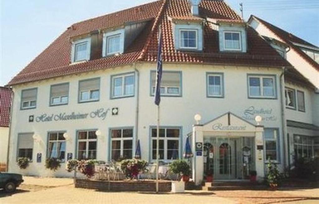 a large white building with a red roof at Garni Hotel Maselheimer Hof in Maselheim