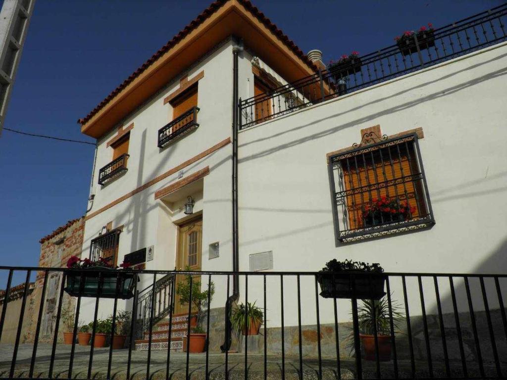 un bâtiment blanc avec une clôture devant lui dans l'établissement Casa Rural del Aire Torrellas TarazonaMoncayo, à Torrelles