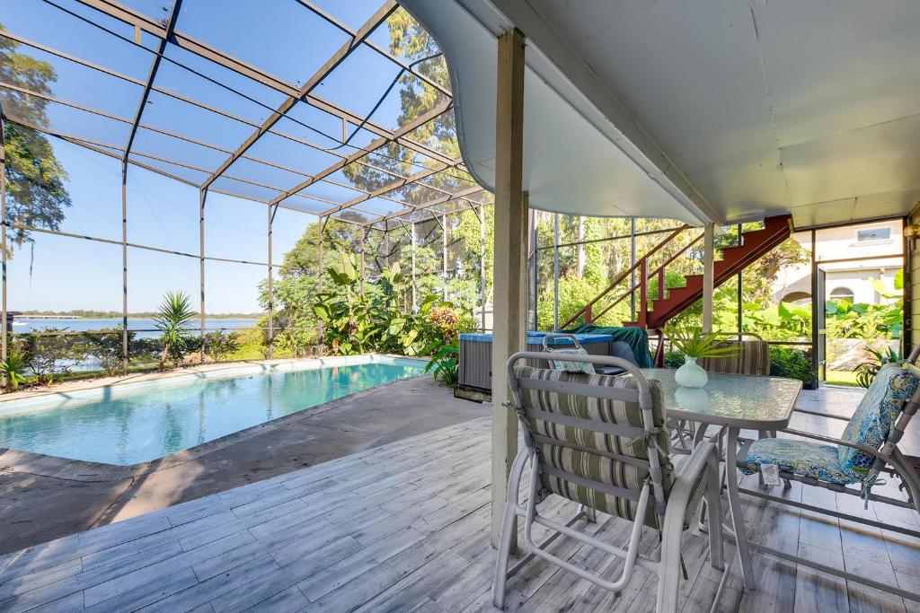a patio with a table and chairs next to a swimming pool at Spacious Lakefront House with Pool, Hottub, & Boating in Orlando