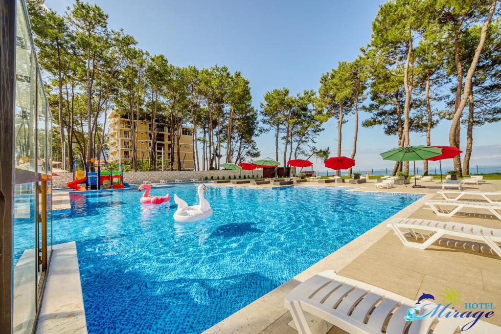 una piscina con cisnes e inflables en un complejo en Mirage Hotel, en Shekhvetili