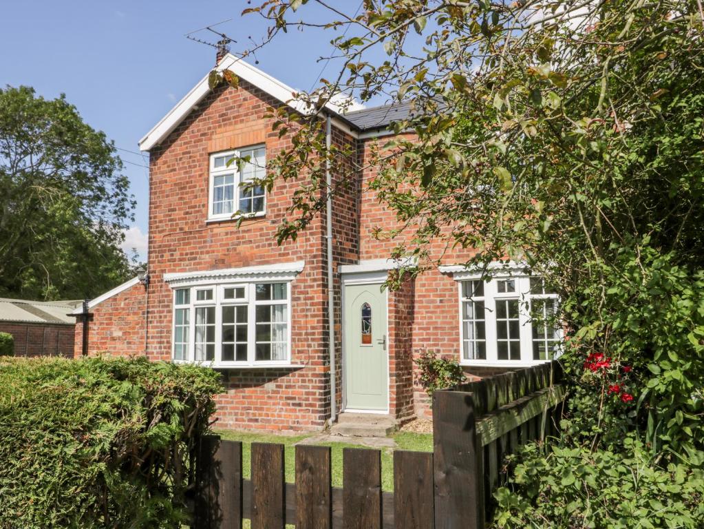 a red brick house with a wooden fence at Ryeby Garth in Hull