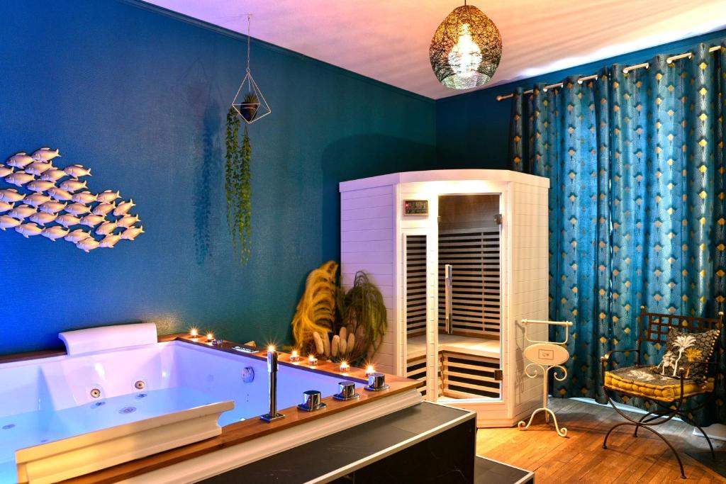 bañera en una habitación con paredes azules en MoonLOVE, SPA/Sauna et Jacuzzi privés, charme et détente., en Nancy