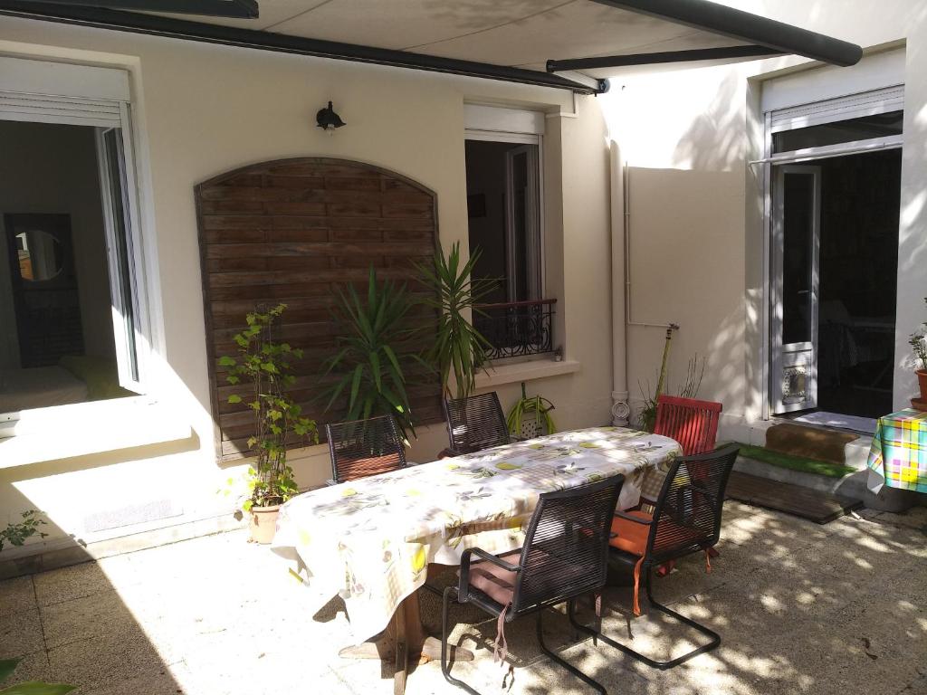 een patio met een tafel en stoelen in een huis bij cosy rare 2 bedroom apartment around a private garden in Neuilly-sur-Seine