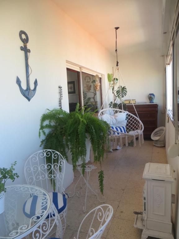 een kamer met een tafel en stoelen en een schommel bij Caparica for Rent in Costa da Caparica