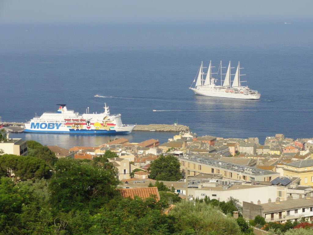 Zwei Schiffe sind im Wasser in der Nähe einer Stadt angedockt. in der Unterkunft Charmantes chambres 792 Route Inférieure de Cardo in Bastia