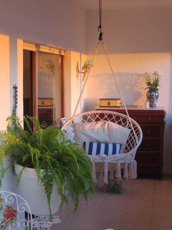 a swing in a room with plants and a dresser at Caparica for Rent in Costa da Caparica