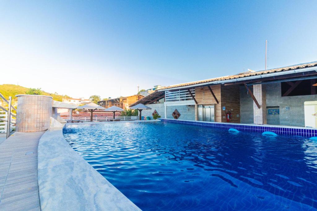 a swimming pool with blue water in front of a building at Flat Pipa's Bay in Pipa