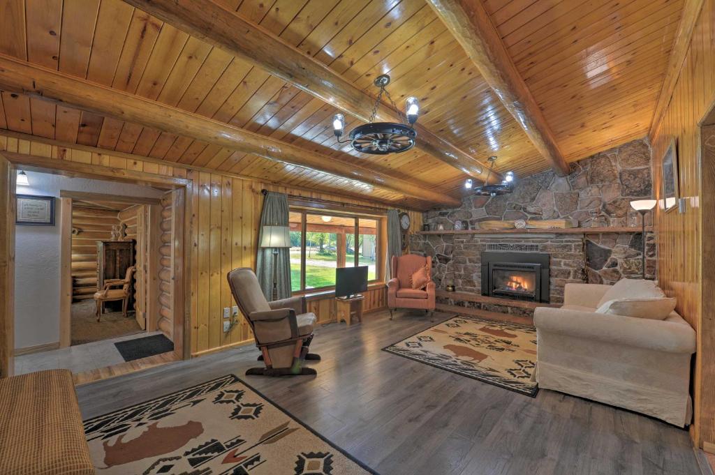 a living room with a stone fireplace in a log cabin at Cozy WY Home Rivers, Lakes, Mountains, Wildlife in Pinedale