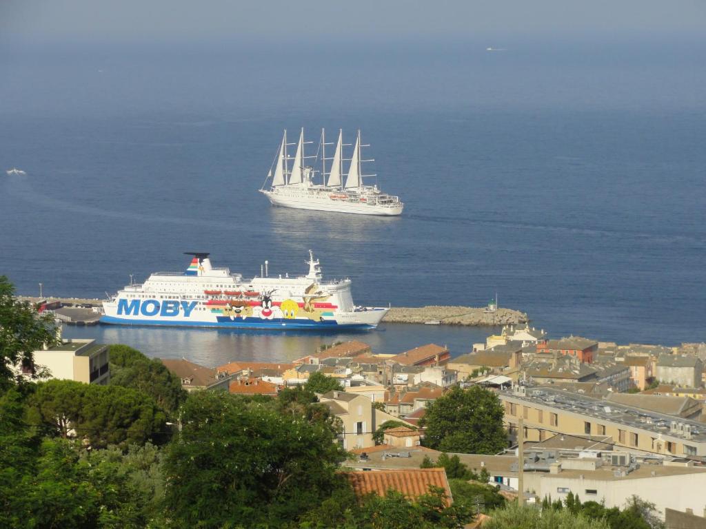 dois navios estão ancorados na água perto de uma cidade em Chambre Élégante Lisa em Bastia