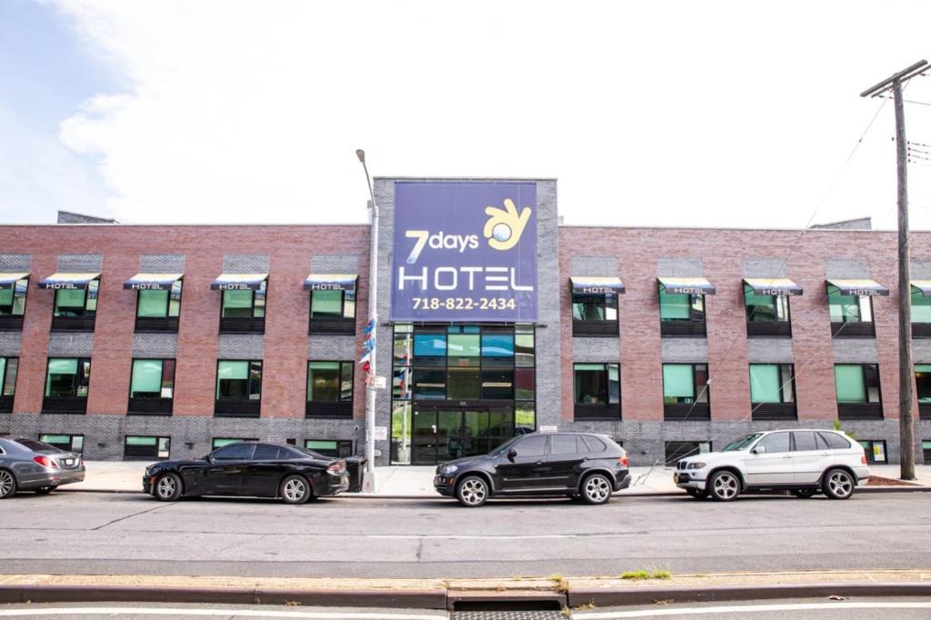 a group of cars parked in front of a building at 7 Days Hotel in Bronx