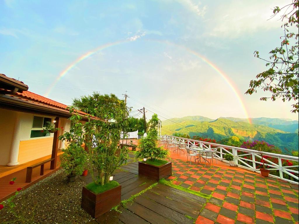 a rainbow over a balcony with a view of a mountain at Alishan Tea Garden B&amp;B in Fenqihu