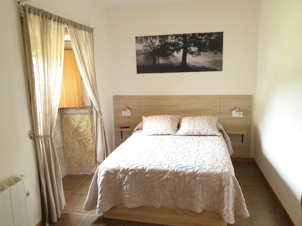sypialnia z łóżkiem i oknem w obiekcie Albergue Rectoral San Mamede da Pena EXCLUSIVE FOR PILGRIMS w mieście Negreira