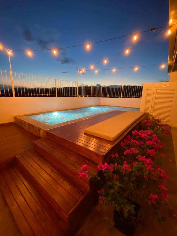 un patio trasero con piscina y terraza con flores en CasaBlanca ApartaEstudios, en Girardot