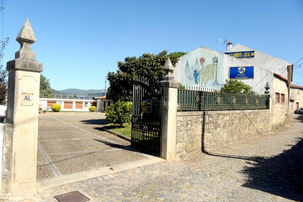 une clôture en pierre avec une porte en face d'un bâtiment dans l'établissement casa das pombas, à Barcelos