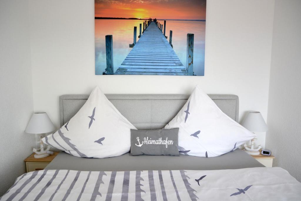 a bed with a painting of a pier at Lakeview Penthouse in Meersburg